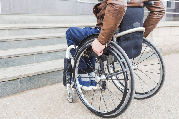 Hombre en silla de ruedas delante de las escaleras
. - Foto, imagen