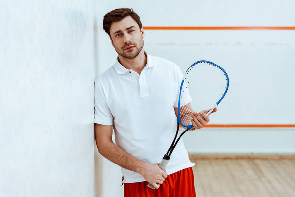 Bearded squash player holding racket and looking at camera - Fotó, kép
