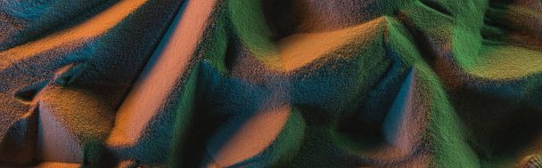 panoramic shot of textured sand with orange, green and blue lights - Fotografie, Obrázek