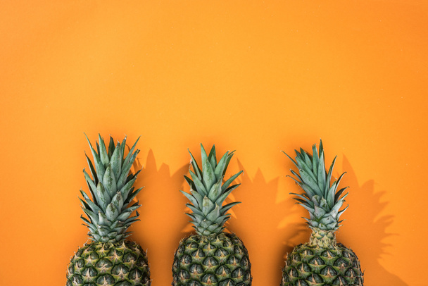 top view of pineapples on orange background with copy space - 写真・画像