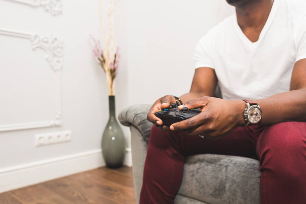 Young African American man playing a game console at home. - Foto, immagini