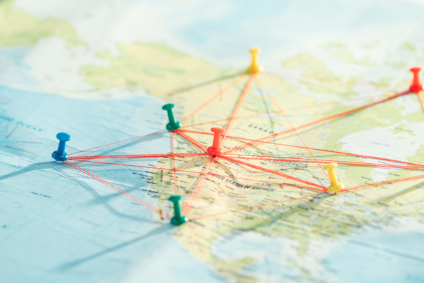 Selective focus of push pins and strings on world map - Photo, Image