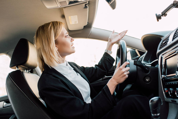 mujer joven rubia molesto gesto mientras está sentado en el coche
  - Foto, imagen