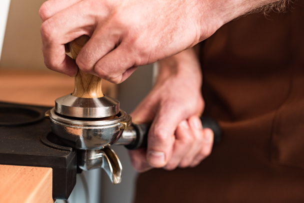 Częściowy widok Barista w brązowym fartuch przygotowywania kawy - Zdjęcie, obraz