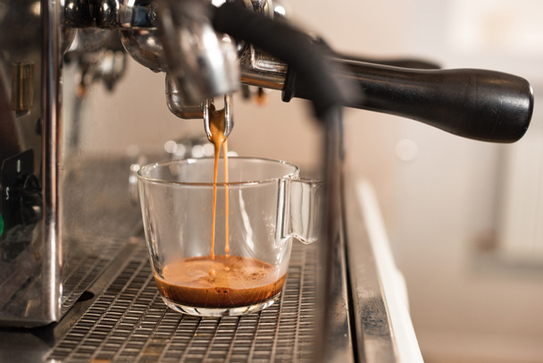 selektive Fokussierung von Kaffeemaschine und Glasschale mit Kaffee - Foto, Bild