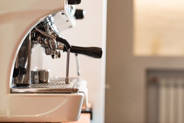 Вид сбоку на современную кофемашину с портафильтром в кафе
 - Фото, изображение