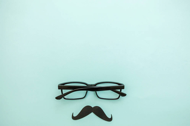 幸福な父の日の概念。パステルブルーの背景上に隔離された眼鏡で口ひげのサイン。マンシルエットシンボル - 写真・画像