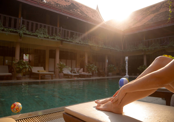 Beautiful tanned women legs by the swimming pool - Фото, зображення