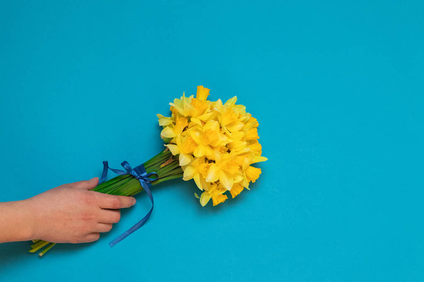 Female hand with a bouquet of the yellow narcissuses - Fotografie, Obrázek