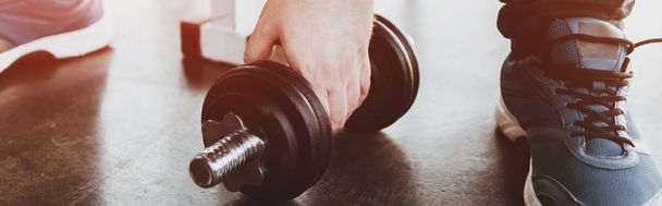 panoramic shot of man training with dumbbell at gym with sunshine - 写真・画像