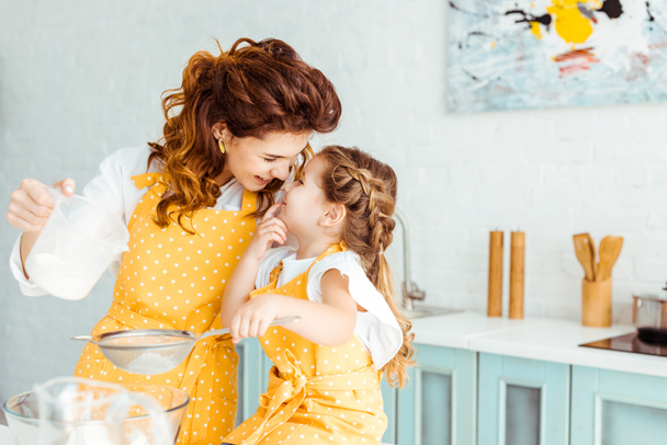 selektywne skupienie cute matka i córka przesiewanie mąki razem w kuchni - Zdjęcie, obraz