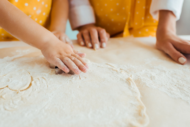 partial view of daughter using heart shaped dough mold - Foto, Imagem