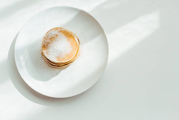 vista superior de sabrosos panqueques con azúcar en polvo en el plato
  - Foto, imagen