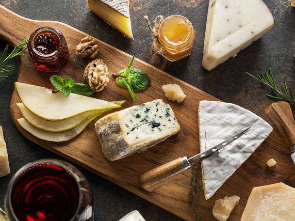 Cheese platter with different cheeses, fruits, nuts and wine on  - Photo, image