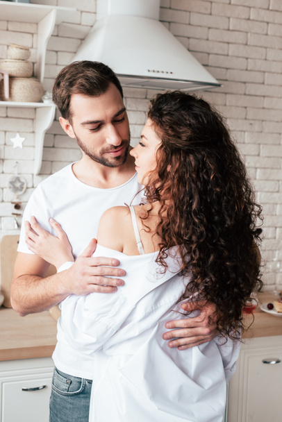 casal amoroso abraçando na cozinha aconchegante de manhã
 - Foto, Imagem