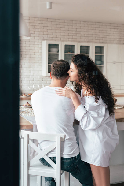 sexy curly young woman in white shirt whispering to boyfriend - Fotografie, Obrázek