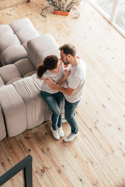overhead view of couple kissing and embracing in living room - Foto, immagini