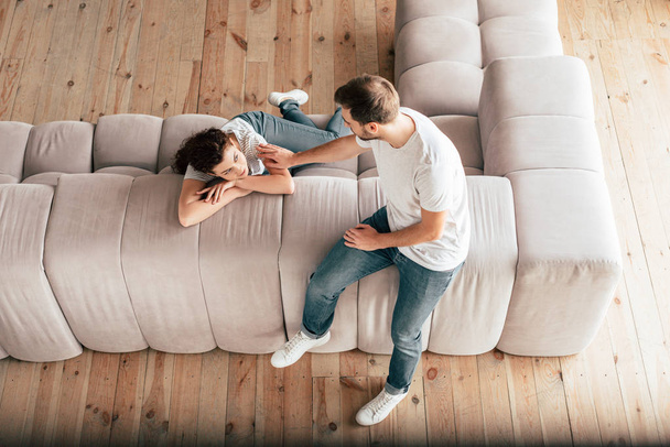 overhead view of couple sitting on sofa and looking at each other - Photo, Image
