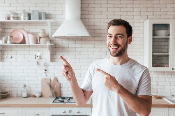 smiling bearded man pointing with fingers and looking at camera - Φωτογραφία, εικόνα