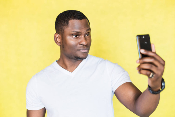 African American man taking selfie on smartphone. - 写真・画像