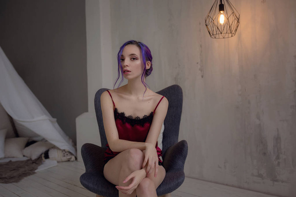 Hermosa joven bailarina elegante posando cerca de una lámpara inusual en su habitación
. - Foto, Imagen