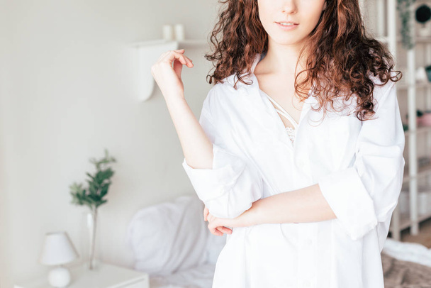частковий вид на молоду жінку в білій сорочці в спальні
 - Фото, зображення