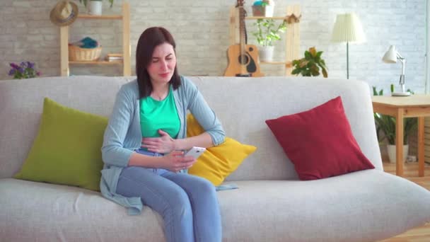 Acute abdominal pain in a woman using a smartphone - Felvétel, videó