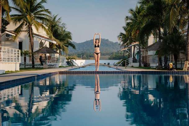 Full length shot of a slim young woman in swimwear at the poolside. - Fotó, kép