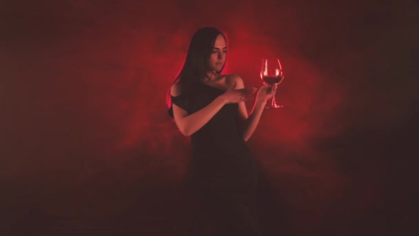 Nő egy pohár vörösbort piros füst - Felvétel, videó