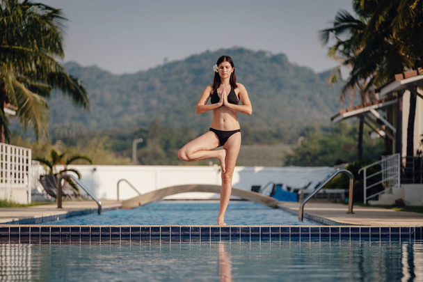mladá žena cvičila jóga na plaveckém bazénu - Fotografie, Obrázek