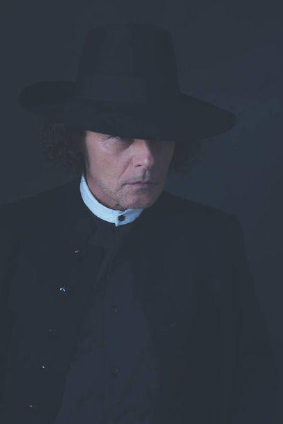 Таємничий вікторіанський чоловік у капелюсі та чорному пальто
. - Фото, зображення