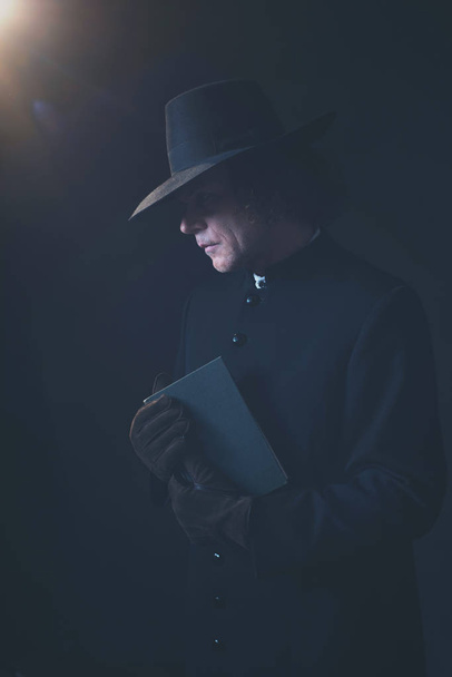 Mysterieuze Victoriaanse priester in Hat Holding boek. - Foto, afbeelding