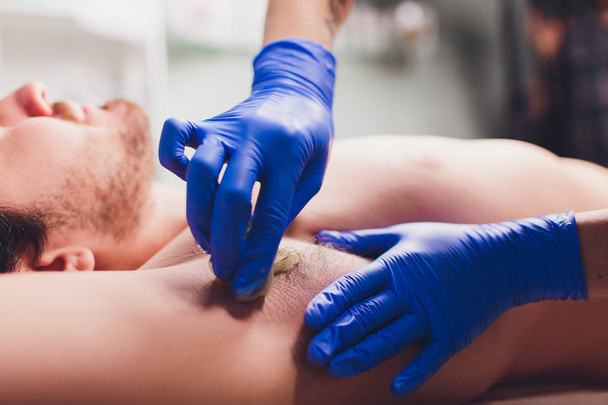 men sugaring hair removal armpit salon male. - Foto, Imagem