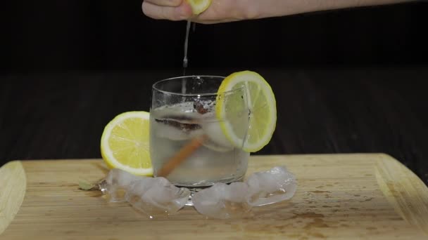 Squeezing lemon juice into a glass. Fornt view - Footage, Video