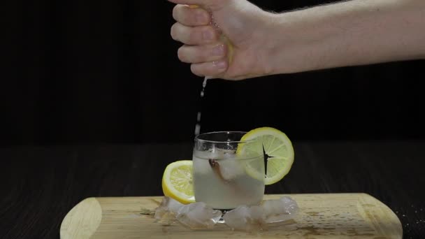 Wyciskając sok z cytryny do szklanki. Widok fornt - Materiał filmowy, wideo