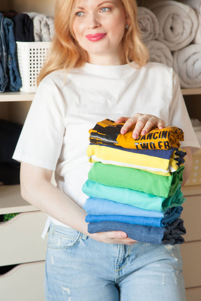 Woman folds clothes vertically on a wardrobe shelf. Japanese sto - Zdjęcie, obraz