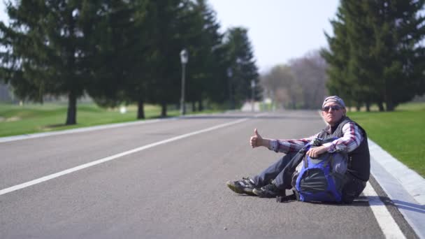  Homem adulto positivo a pedir boleia a parar o carro na estrada vazia. Slider tiro
 - Filmagem, Vídeo