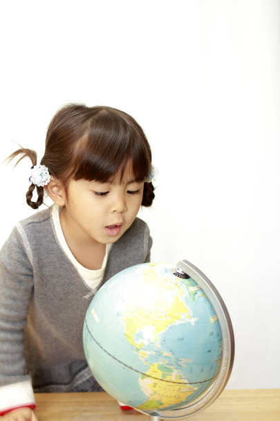 Földgömb és a japán lány (4 éves) - Fotó, kép