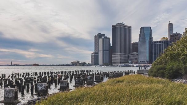 Skyscrapers of downtown Manhattan over East River, viewed from Brooklyn Bridge Park, in Brooklyn, New York, USA - Photo, Image
