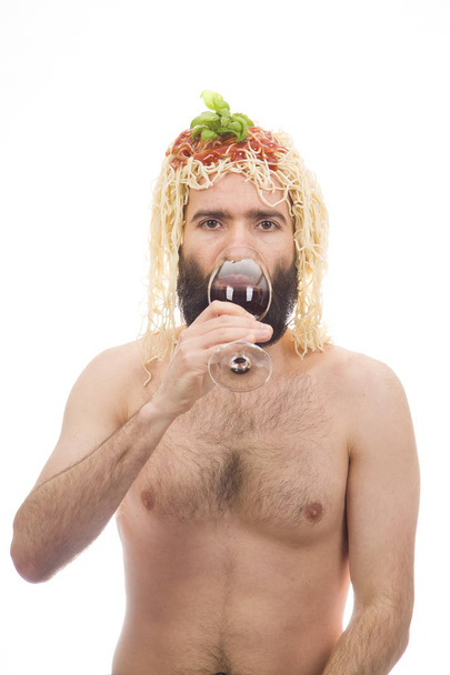 Bearded, grappig, jonge man met spaghetti op zijn hoofd. Het drinken van wijn. Glas. Witte achtergrond. Lichaam zonder kleding. Portret foto. Blanke man. - Foto, afbeelding