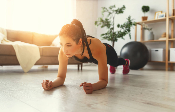 jonge vrouw bezig met fitness en sport thuis     - Foto, afbeelding