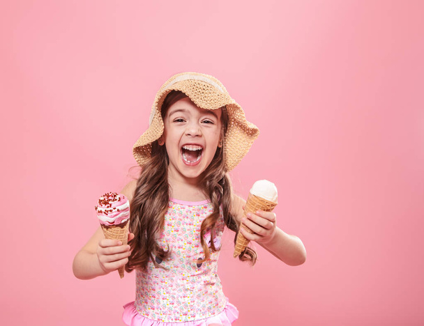 Portrait of a little cheerful girl with ice cream on a colored background - Foto, Imagem