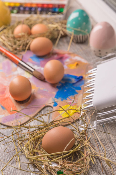 Young woman painting Easter eggs, white covered table.Preparation for happy Easter holiday.Woman hands painting decorative colorful eggs, handmade Easter craft top view - Foto, Bild