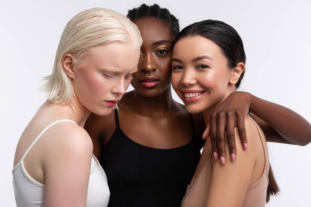 Women with different complexion feeling joyful hugging - Photo, Image