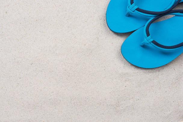 Siniset flipflopit hiekkarannalla, yläpuolella
 - Valokuva, kuva