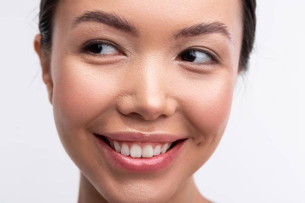Woman with shiny and natural makeup smiling broadly - Fotoğraf, Görsel