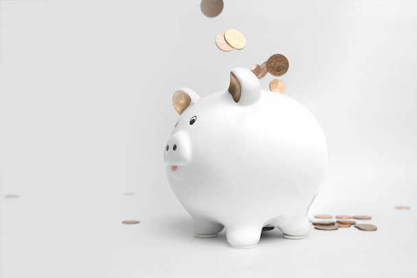 Sparschwein wei mit Geldmuenzen - 写真・画像