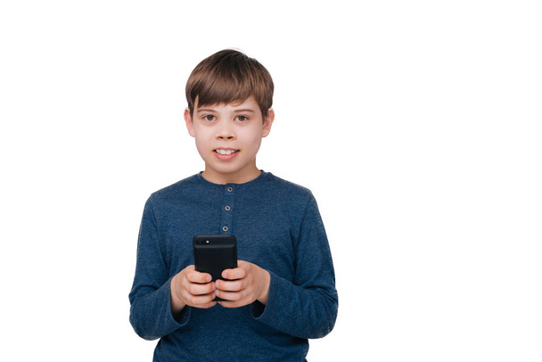 Un bambino che tiene in mano un cellulare e guarda la fotocamera su uno sfondo isolato
  - Foto, immagini