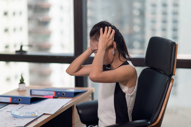 Femme d'affaires stressée avec la paume sur le visage dans son bureau
 - Photo, image