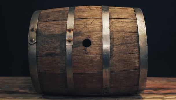 Wooden barrel on a old oak table. Black background behind. - Photo, Image